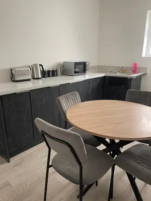 a wooden table and chairs in a kitchen with a counter at Ground Floor - Balmoral Stays - Apartment 2 - Sleeps 6 Free WiFi in Blackpool