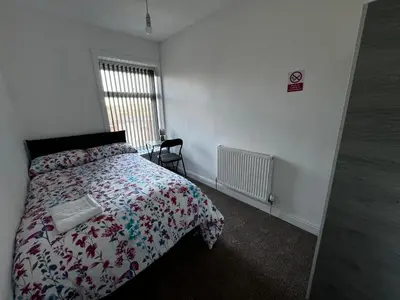 a bedroom with a bed with a comforter and a window at Double Bed BW2 Accrington Burnley in Accrington