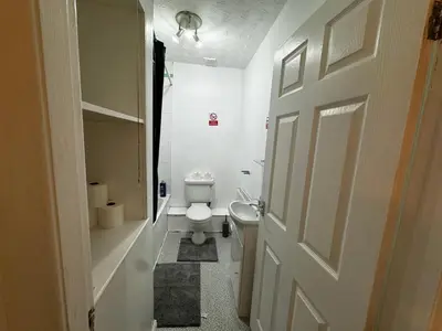 a white bathroom with a toilet and a door at Double bed BW3 Accrington Burnley in Accrington