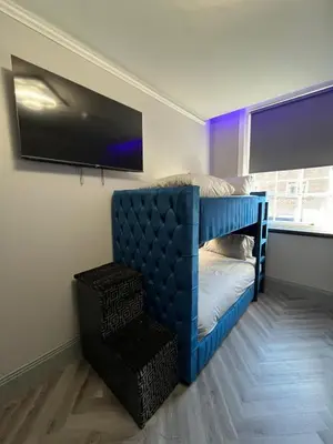a bedroom with a blue bed and a tv at 101 Bold Street Apartments in Liverpool