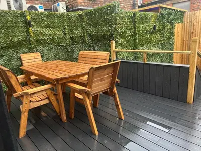 a wooden table and two chairs on a deck at 101 Bold Street Apartments in Liverpool