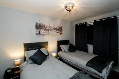 a bedroom with two beds and a chandelier at Swindon Dream in Liverpool