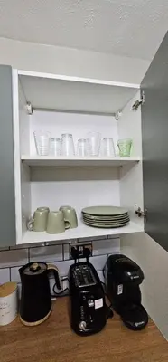 a cupboard with plates and dishes in it at Swindon Dream in Liverpool