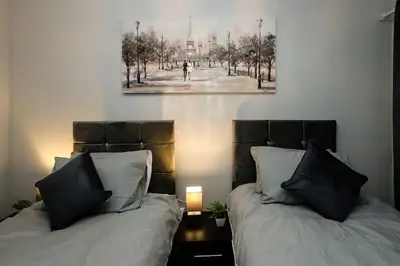 two beds in a room with a picture on the wall at Swindon Dream in Liverpool