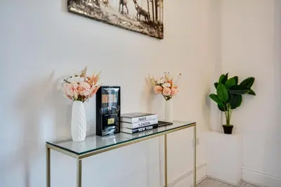a glass table with two vases and flowers on it at Wigan - Apartment - Sleeps 3 - Parking - Stadium in Wigan