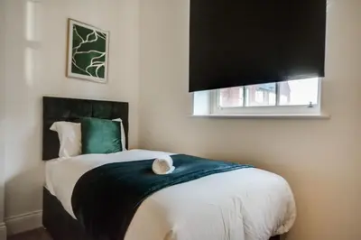 a bedroom with a bed with a cat sitting on it at Wigan - Apartment - Sleeps 3 - Parking - Stadium in Wigan