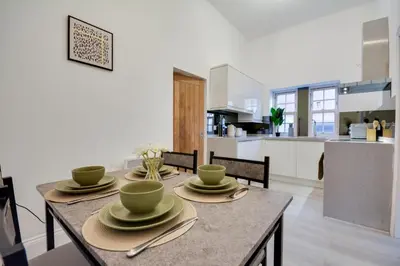 a kitchen and dining room with a table and chairs at Wigan - Apartment - Sleeps 3 - Parking - Stadium in Wigan