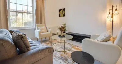 a living room with a couch and chairs and a table at Wigan - Apartment - Sleeps 3 - Parking - Stadium in Wigan