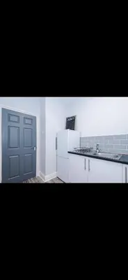 a kitchen with a white refrigerator and a door at Walton Residence in Liverpool