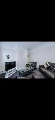 a living room with leather couches and a television at Walton Residence in Liverpool