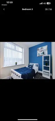 a bedroom with a bed and a blue wall at Walton Residence in Liverpool