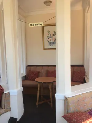 a room with a couch and a table with a sign that reads meet the shop at The Fernroyd in Blackpool