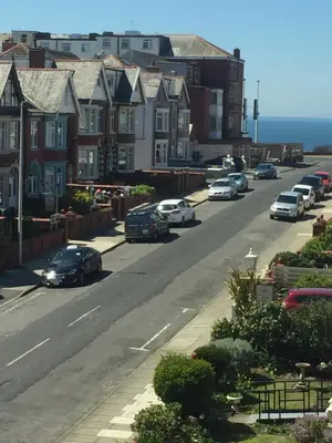 a street with cars parked on the side of the road at The Fernroyd in Blackpool