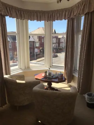 a living room with two chairs and a table in front of a window at The Fernroyd in Blackpool