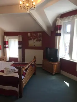 a bedroom with a bed and a flat screen tv at The Fernroyd in Blackpool