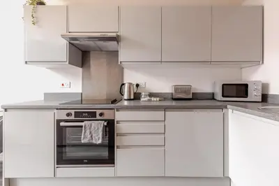 a kitchen with white cabinets and a stove top oven at Spacious 2Bed Central Liverpool Nightlife & Events, sleeps up to 10 in Liverpool