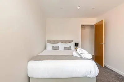 a white bedroom with a large bed with white sheets at Spacious 2Bed Central Liverpool Nightlife & Events, sleeps up to 10 in Liverpool