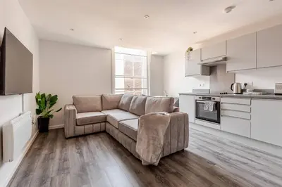 a living room with a couch and a kitchen at Spacious 2Bed Central Liverpool Nightlife & Events, sleeps up to 10 in Liverpool