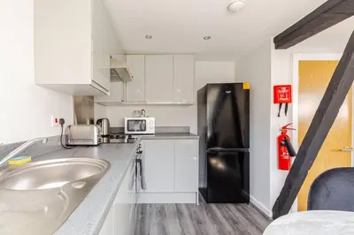 a kitchen with a sink and a black refrigerator at 2-Bed Apartment with Sofa Bed, Sleeps up to 6, Perfect for Groups & Familie in Liverpool