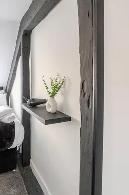 a room with a shelf with a plant in a vase at 2-Bed Apartment with Sofa Bed, Sleeps up to 6, Perfect for Groups & Familie in Liverpool