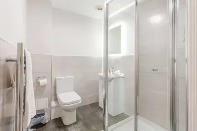 a white bathroom with a toilet and a shower at 2-Bed Apartment with Sofa Bed, Sleeps up to 6, Perfect for Groups & Familie in Liverpool