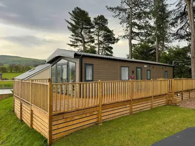 a house with a wooden fence around it at Glenmoor Lodge in Clitheroe