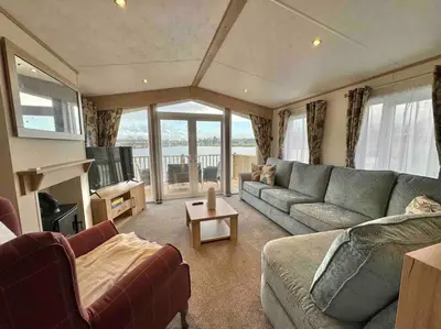 a living room with a couch and a tv at Glenmoor Lodge in Clitheroe