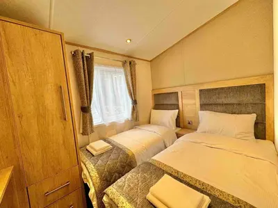 a small bedroom with two beds and a window at Glenmoor Lodge in Clitheroe