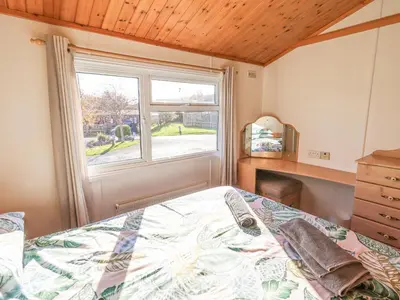 a bedroom with a bed and a window at Kellet Lodge Lakeside 26 in Carnforth