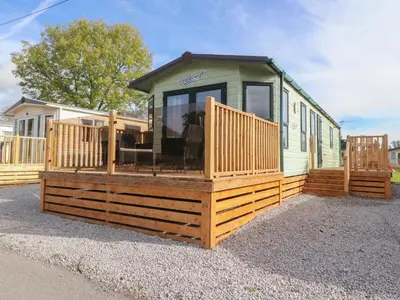 a mobile home with a large deck on the ground at Ashcroft in Preston
