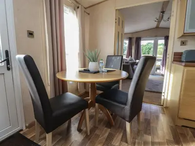 a dining room table with black chairs and a kitchen at Ashcroft in Preston