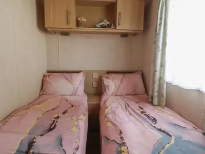 two beds in a small room with pink sheets at Ashcroft in Preston