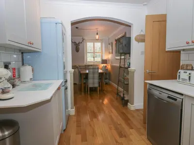 a kitchen with white counters and a dining room at 1 Boarbank Farm in Grange Over Sands