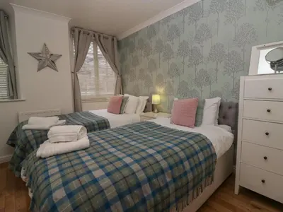 a bedroom with two beds and a dresser at 1 Boarbank Farm in Grange Over Sands