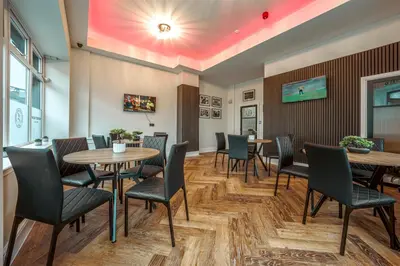a restaurant with tables and chairs and a red ceiling at The Boot Rooms Anfield in Liverpool