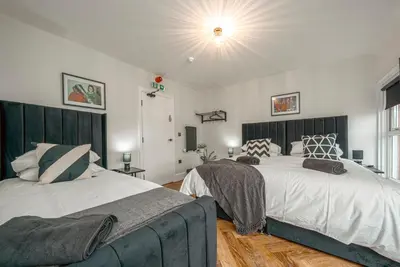 a bedroom with two beds and a large window at The Boot Rooms Anfield in Liverpool