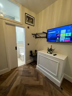 a living room with a large tv on the wall at The Boot Rooms Anfield in Liverpool