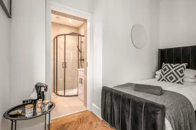 a bedroom with a bed and a walk in shower at The Boot Rooms Anfield in Liverpool