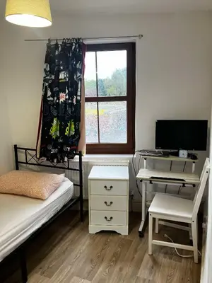 a bedroom with a desk and a computer and a window at Perfect House for Healthcare worker in Barrow in Furness