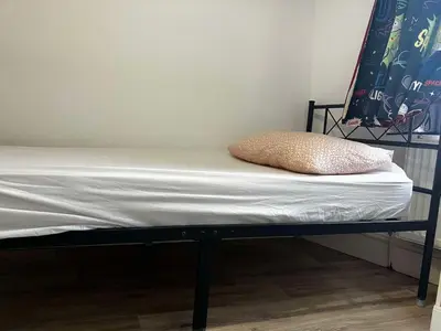 a bed with a black frame and a pillow on it at Perfect House for Healthcare worker in Barrow in Furness
