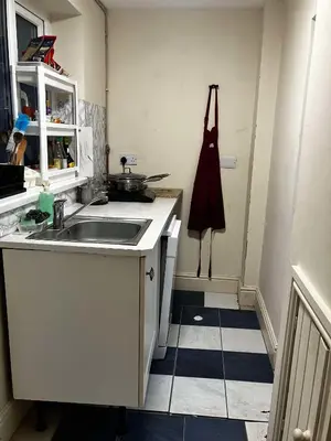 a kitchen with a sink and apron hanging on the wall at Perfect House for Healthcare worker in Barrow in Furness