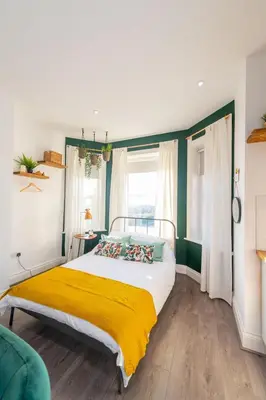 a bedroom with a bed with a yellow blanket at No 27 Liverpool in Liverpool