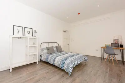 a white bedroom with a bed and a desk at No 27 Liverpool in Liverpool