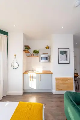 a living room with a kitchen with a microwave at No 27 Liverpool in Liverpool