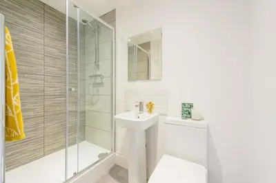 a white bathroom with a sink and a shower at No 27 Liverpool in Liverpool