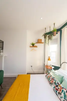 a bedroom with a bed with a yellow blanket at No 27 Liverpool in Liverpool