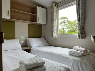 two twin beds in a room with a window at Ribble Valley Lodge in Longridge