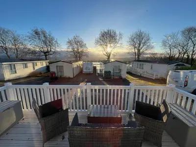 a deck with chairs and a table and some trailers at Ribble Valley Lodge in Longridge