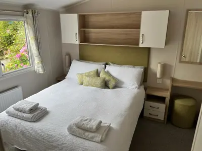 a bedroom with a white bed with towels on it at Ribble Valley Lodge in Longridge