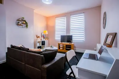 a living room with a couch and a table with a laptop at Westminster Apartment in Liverpool